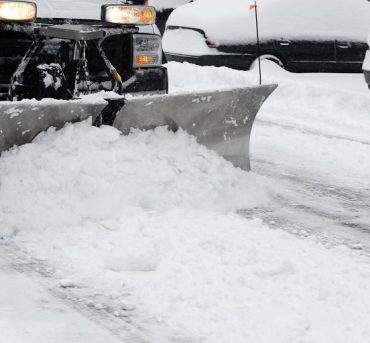 snowplow removing snow on the street after blizzard